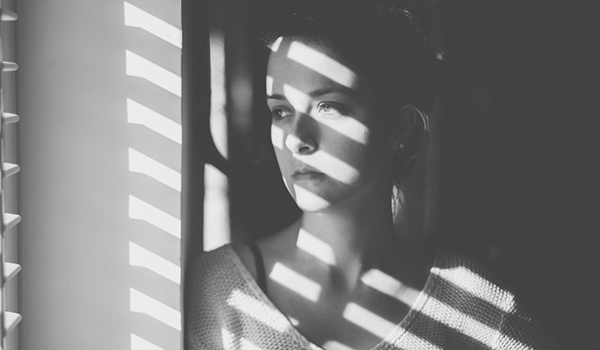 Sad woman looking through the window